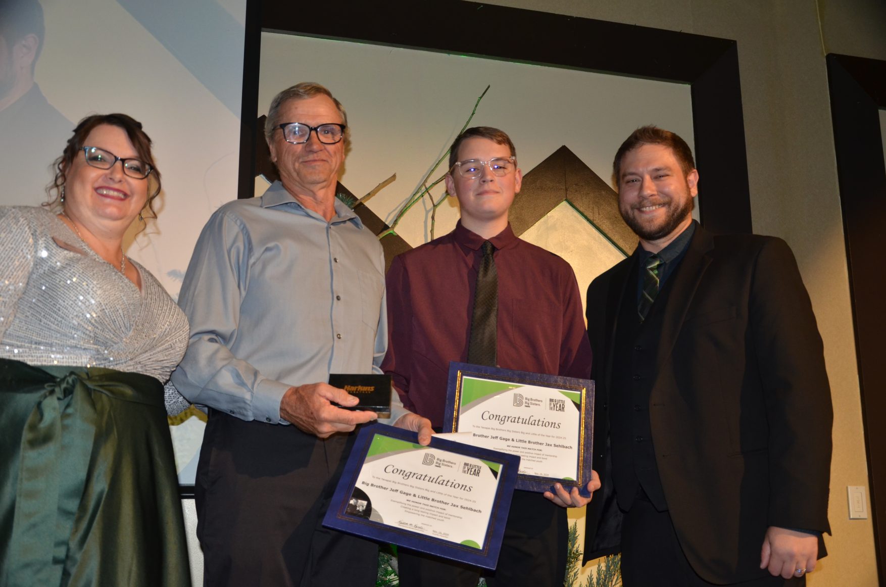 Big Brother Jeff Gage and Little Brother Jax receive their Big and Little of the Year Award from Kristen Kerns, YBBBS Executive Director, and Jonathan Knight, YBBBS board vice-chair from Desert Financial Credit Union. Courtesy/YBBBS.